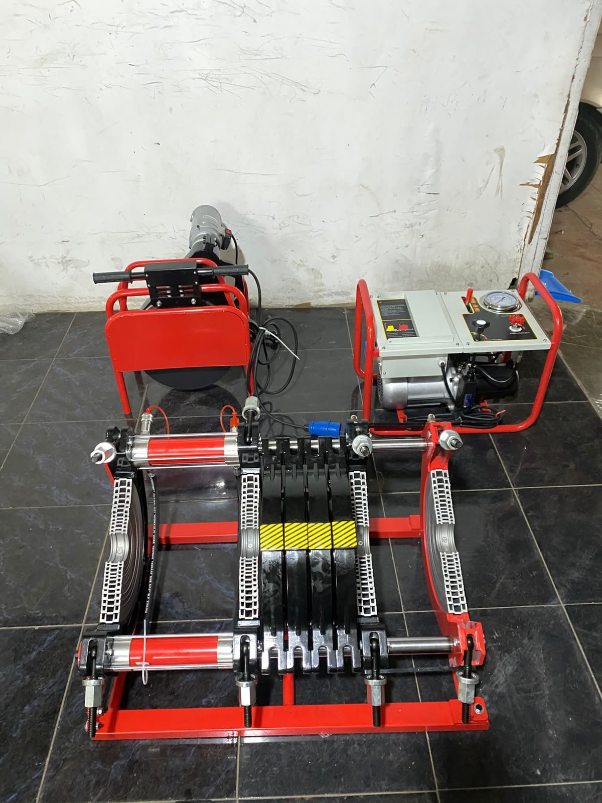 Mesin las pipa HDPE hydraulic berwarna merah dengan unit pompa